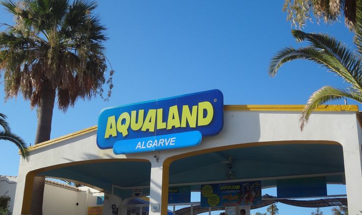 Aqualand Algarve entrance sign with water park rides in the background.