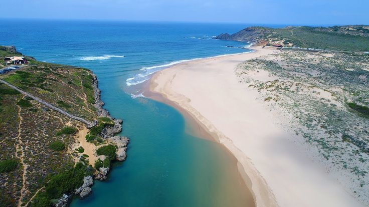 Aerial view of a long sandy beach with waves.